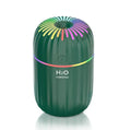 White USB mini humidifier with 300ml tank on a desk next to a laptop.