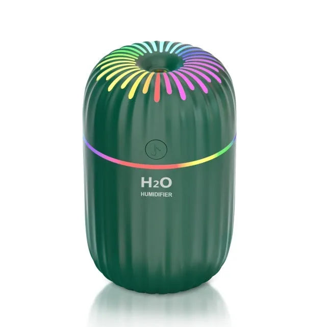 White USB mini humidifier with 300ml tank on a desk next to a laptop.