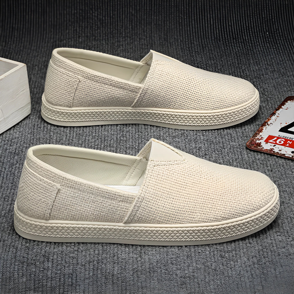 Men's beige canvas slip-on shoes with round toe and PVC sole.