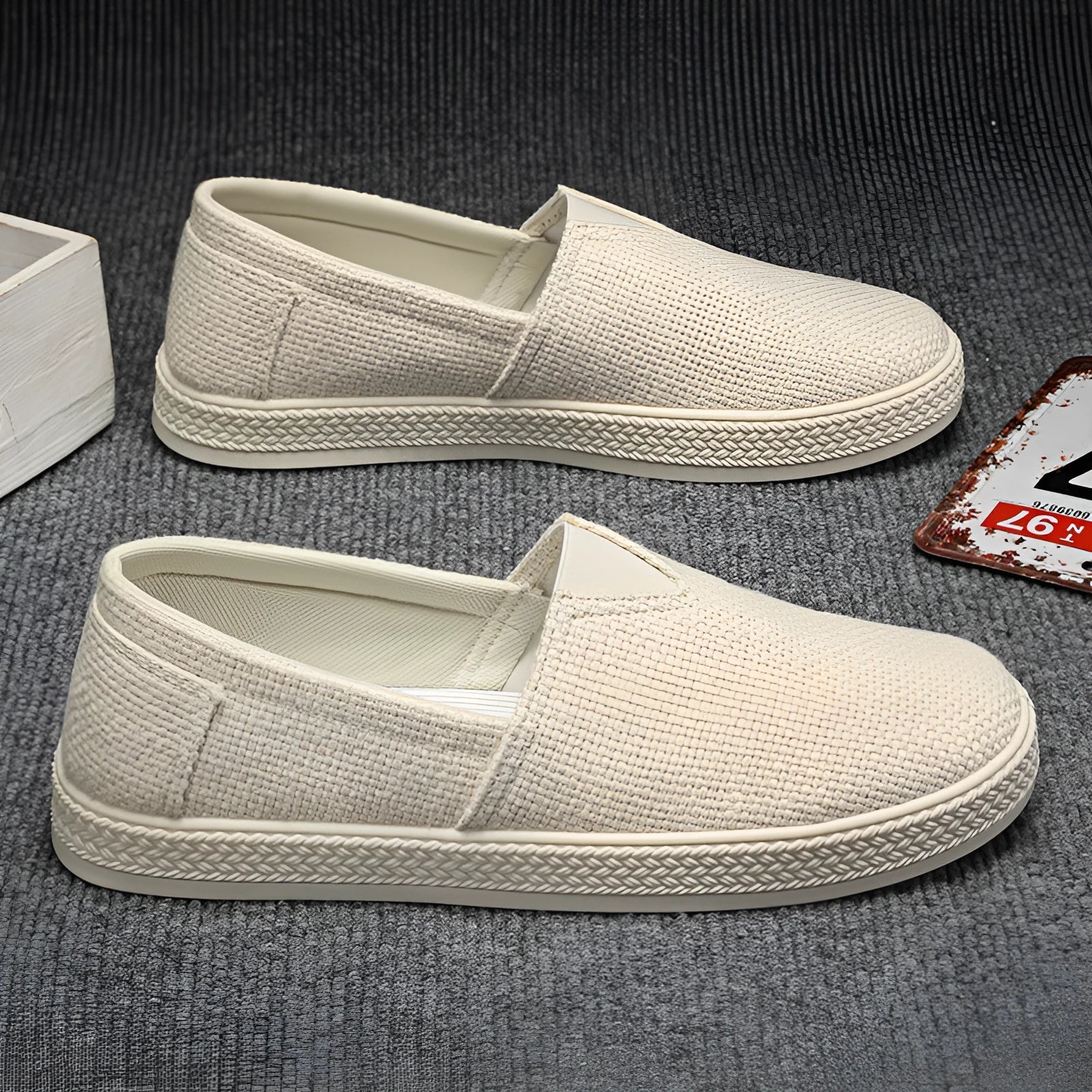 Men's beige canvas slip-on shoes with round toe and PVC sole.