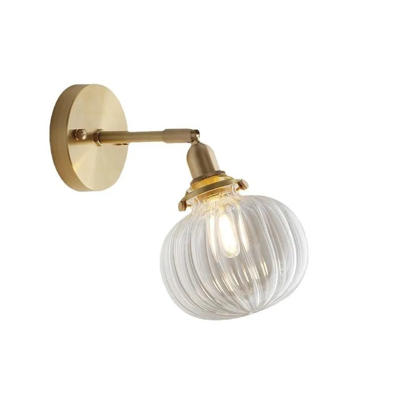 Creative pumpkin-shaped wall lamp with a textured glass shade mounted on a white wall.