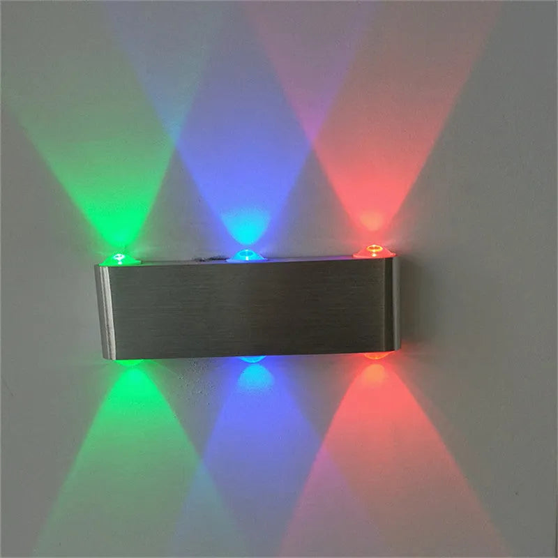 Silver aluminium rectangular LED wall lamp showing seven light colour options including blue, green, and warm white