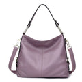 Genuine leather vertical square crossbody bag in black with sewing line detail and external pocket.