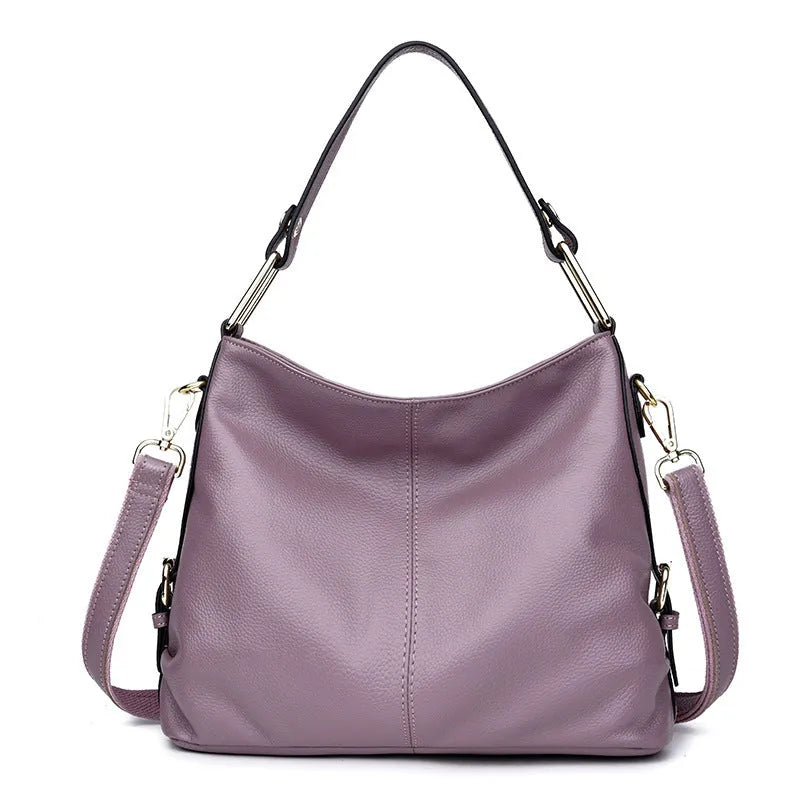 Genuine leather vertical square crossbody bag in black with sewing line detail and external pocket.