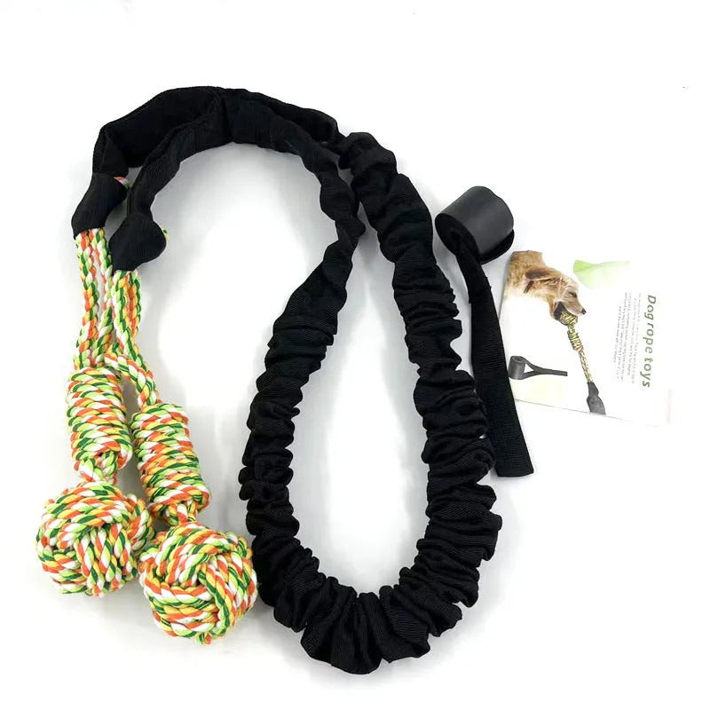 Braided cotton dog tug-of-war rope toy in red, shown with a dog gripping one end.
