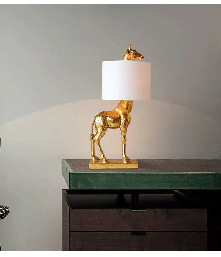 White giraffe table lamp with cloth shade on wooden bedside table