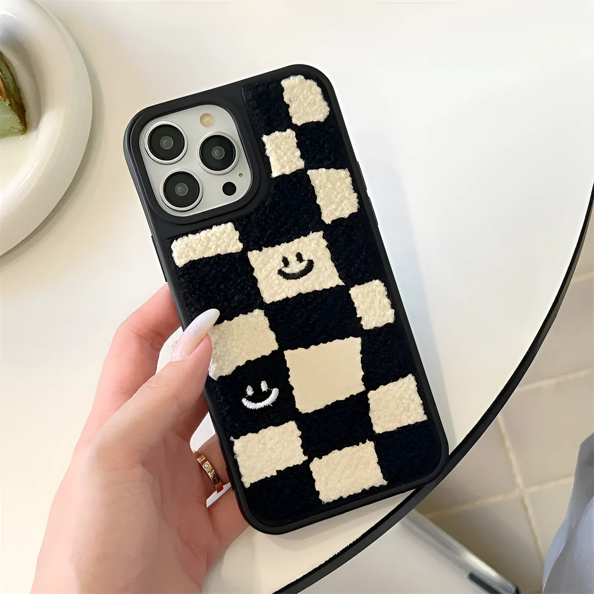 Black and white chessboard TPU phone case for iPhone with precise cutouts on a white background