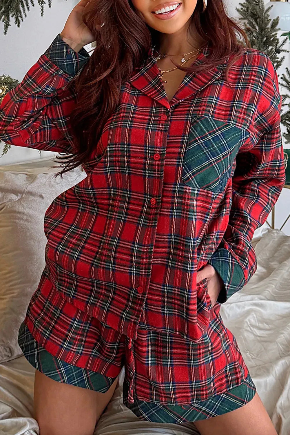 Red and black plaid adult pyjama set with long sleeve shirt and shorts on a hanger.