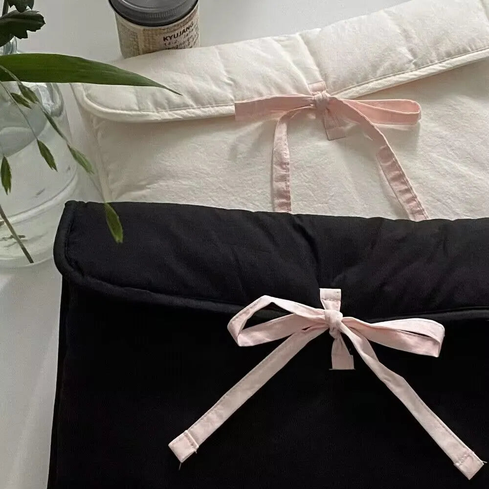 Black and white striped quilted laptop bag for women with a large decorative bow on the front.