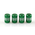 Set of coloured aluminium alloy tyre valve caps for car wheels on a grey background.