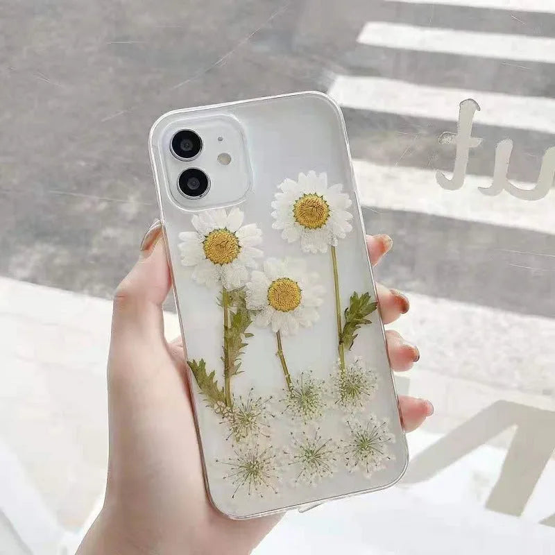 White iPhone case with a raised epoxy daisy floral pattern on the back.