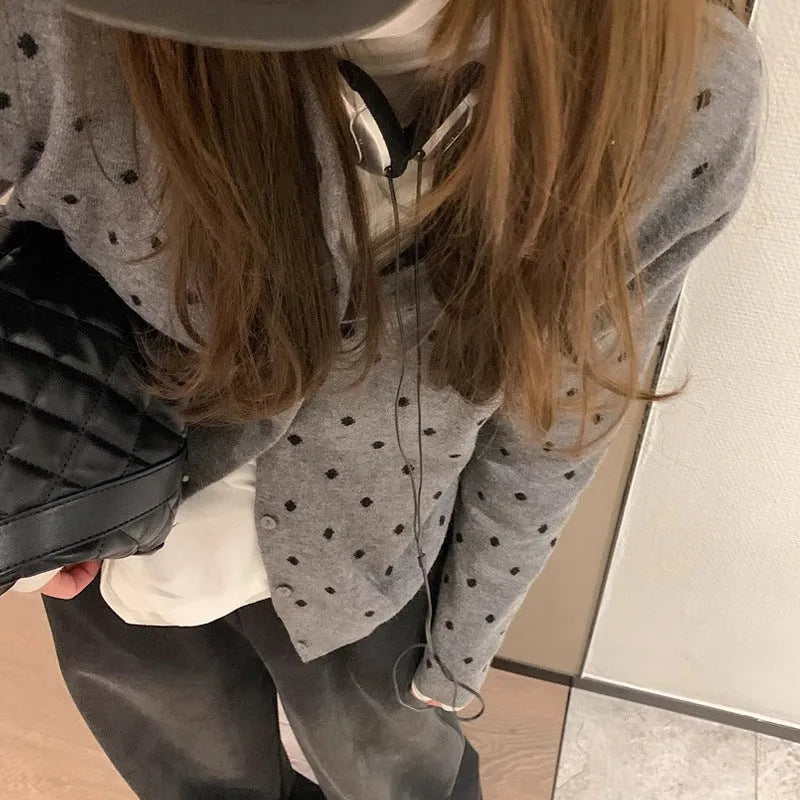 Women's grey dot print knitted cardigan with white crocheted flower detail on sleeve