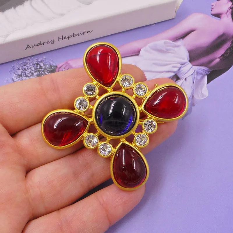 Close-up of vintage medieval baroque cross brooch with crystal accents on zinc alloy.