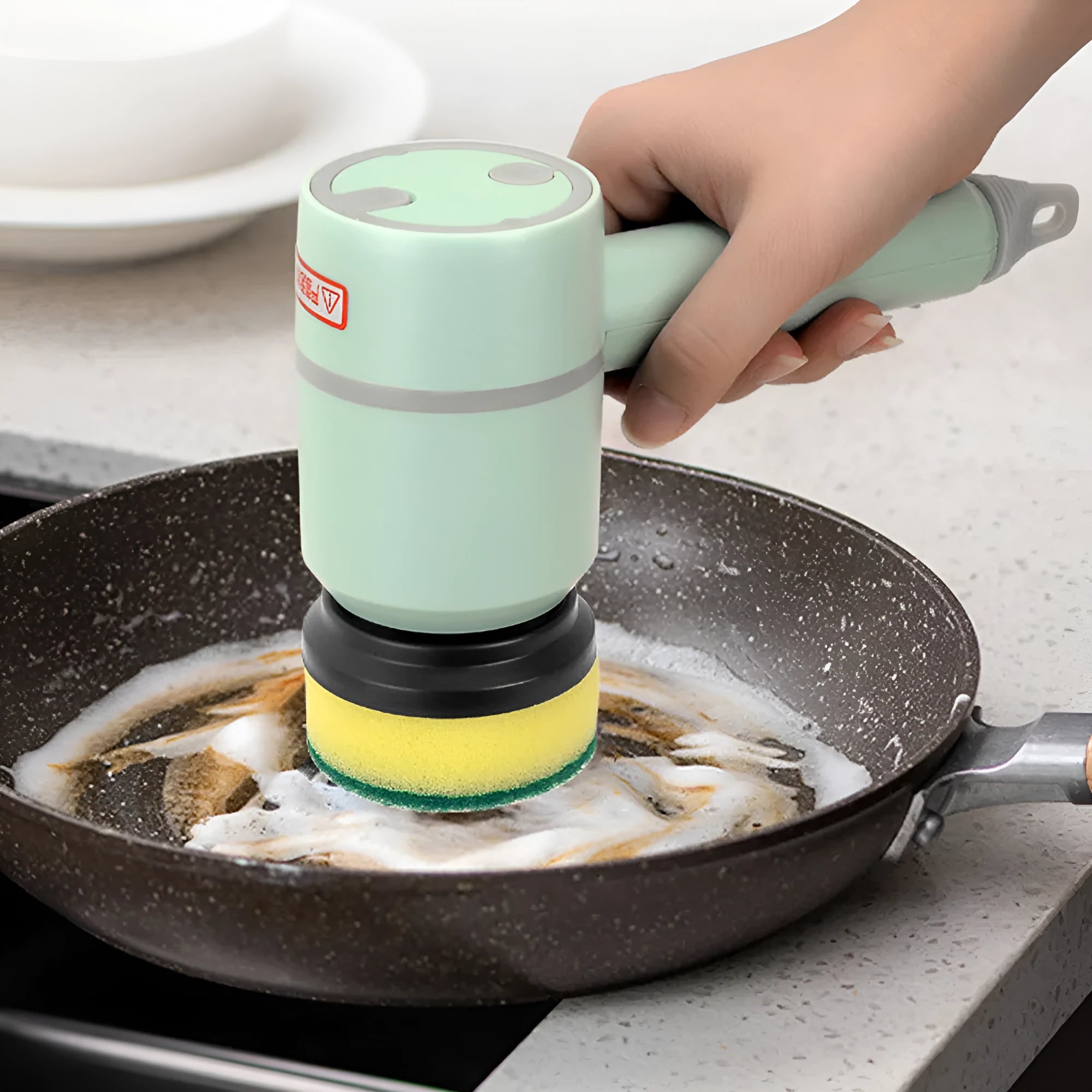 Green electric cleaning brush with three interchangeable scouring pad, brush, and sponge heads on a white background.