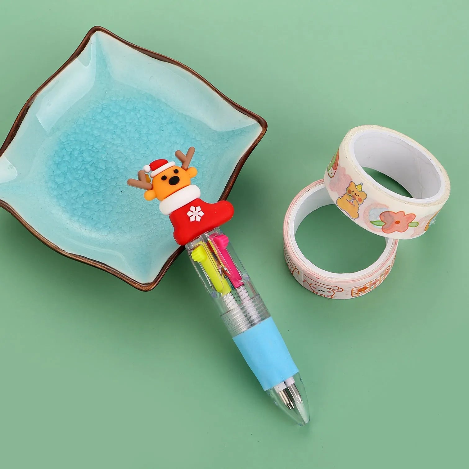 Compact 11cm Christmas ballpoint pen with four colours and festive designs like snowmen and reindeer.