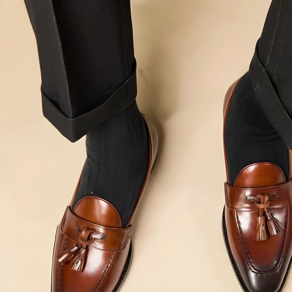 British-style leather tassel loafers in black or brown with polished uppers and traditional tassel detailing