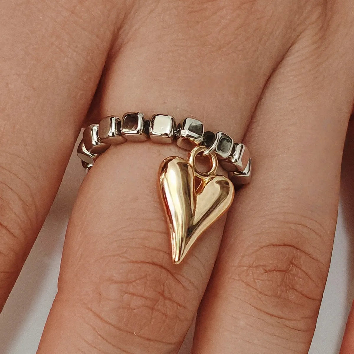 Handmade elastic beaded love ring with geometric heart design in gold and white electroplated finishes