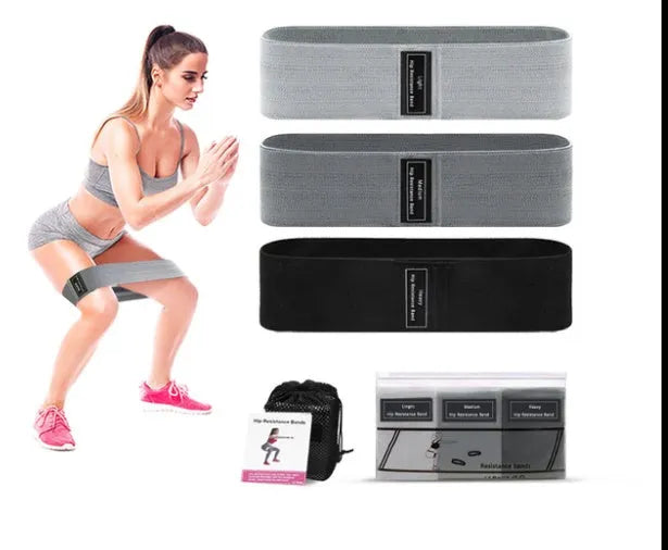 Set of three coloured fabric resistance bands (blue, pink, purple) and a mesh storage bag for fitness training.
