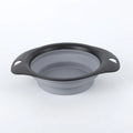 Black silicone pet bowl shown open and folded flat next to a dog leash.