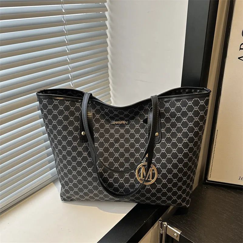 Large black PU leather shoulder bag with sewn thread detailing on a white background.