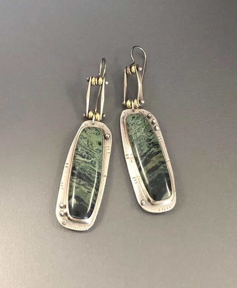 A pair of geometric-shaped alloy earrings with a white and grey marble pattern.