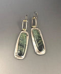 A pair of geometric-shaped alloy earrings with a white and grey marble pattern.