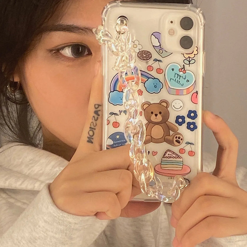 White TPU iPhone case with an attached silver bear pendant on a chain, showing cartoon-style design.