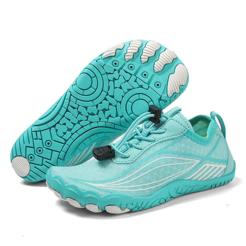 Children's quick-drying water shoes with non-slip rubber soles in multiple colours on a sandy beach.