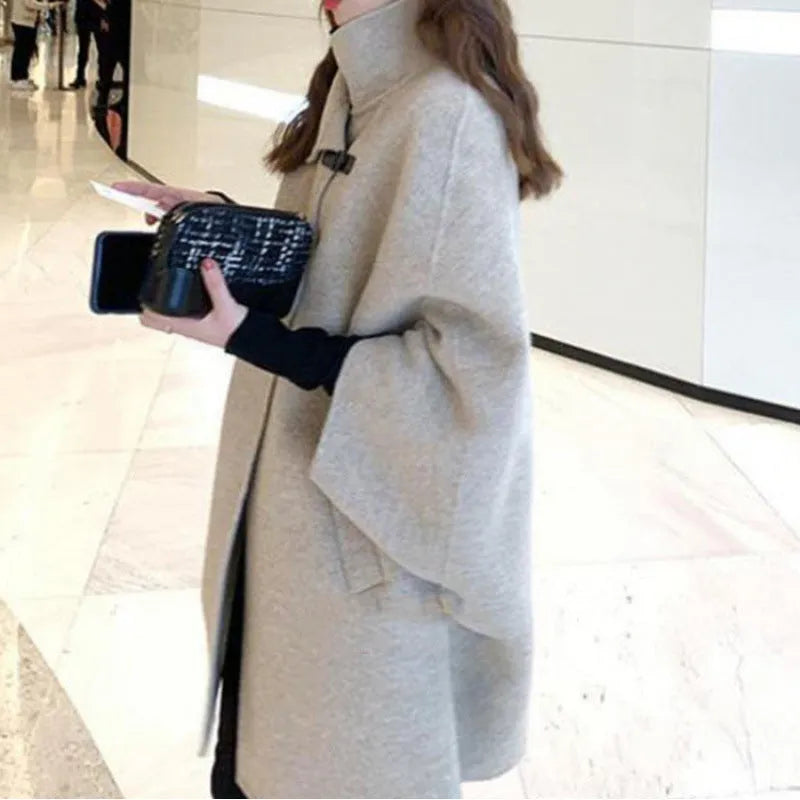 Women's green Korean-style lengthened coat with flight sleeves on a hanger