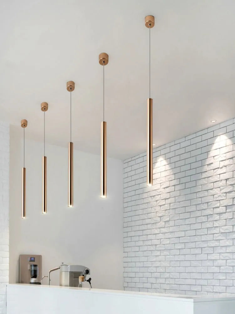 French gold long cylindrical iron chandelier with PMMA lampshade on simple modern background