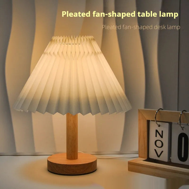 Vintage pleated umbrella-shaped USB bedside lamp with remote control on a wooden table.