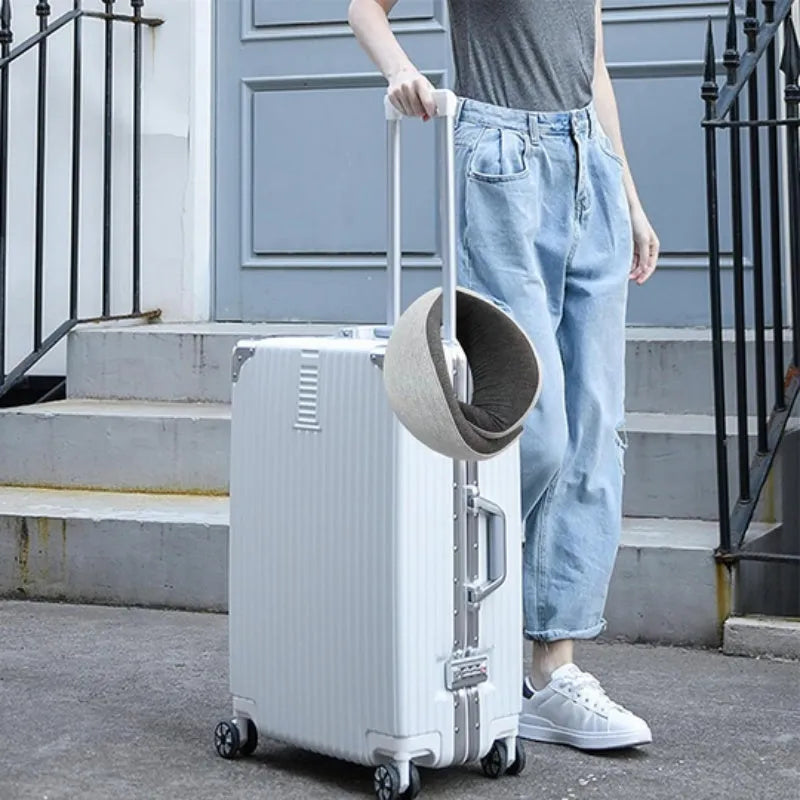 Navy blue U-shaped travel neck pillow rolled up next to its carry bag