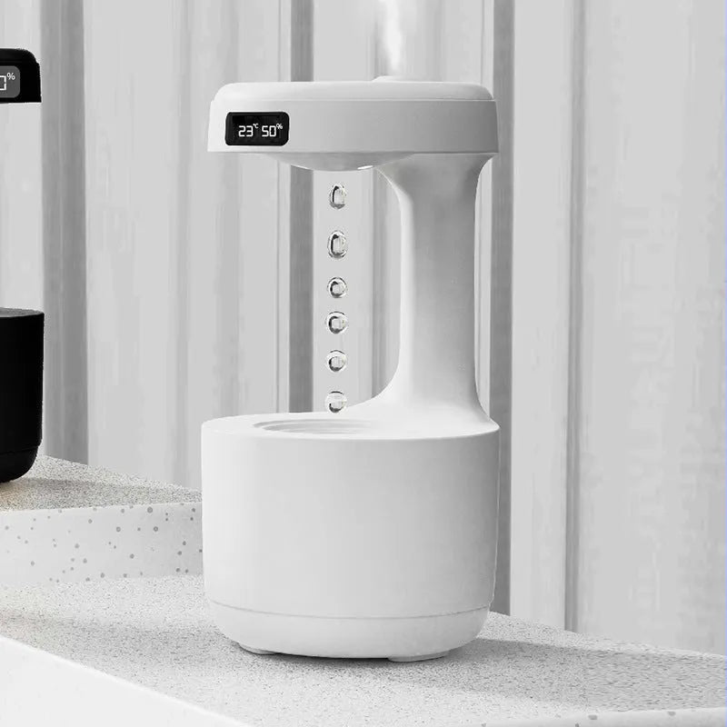 White columnar anti-gravity humidifier with LED clock display and mist output on a wooden desk.