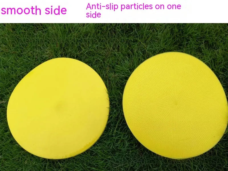 Soft yellow TPE football training target pad flat on grass, 23cm diameter.