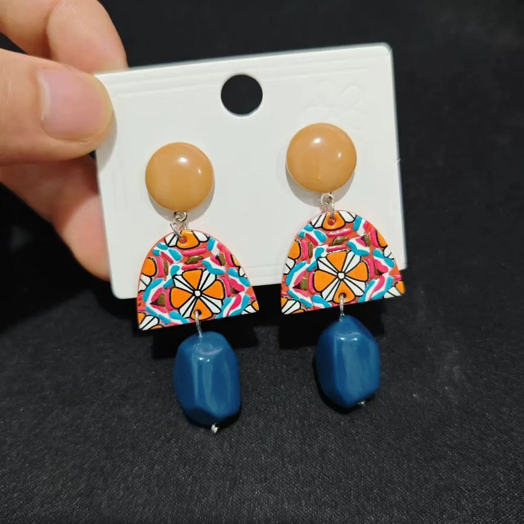 Retro yellow blue contrast acrylic earrings with irregular geometric shapes on white background.