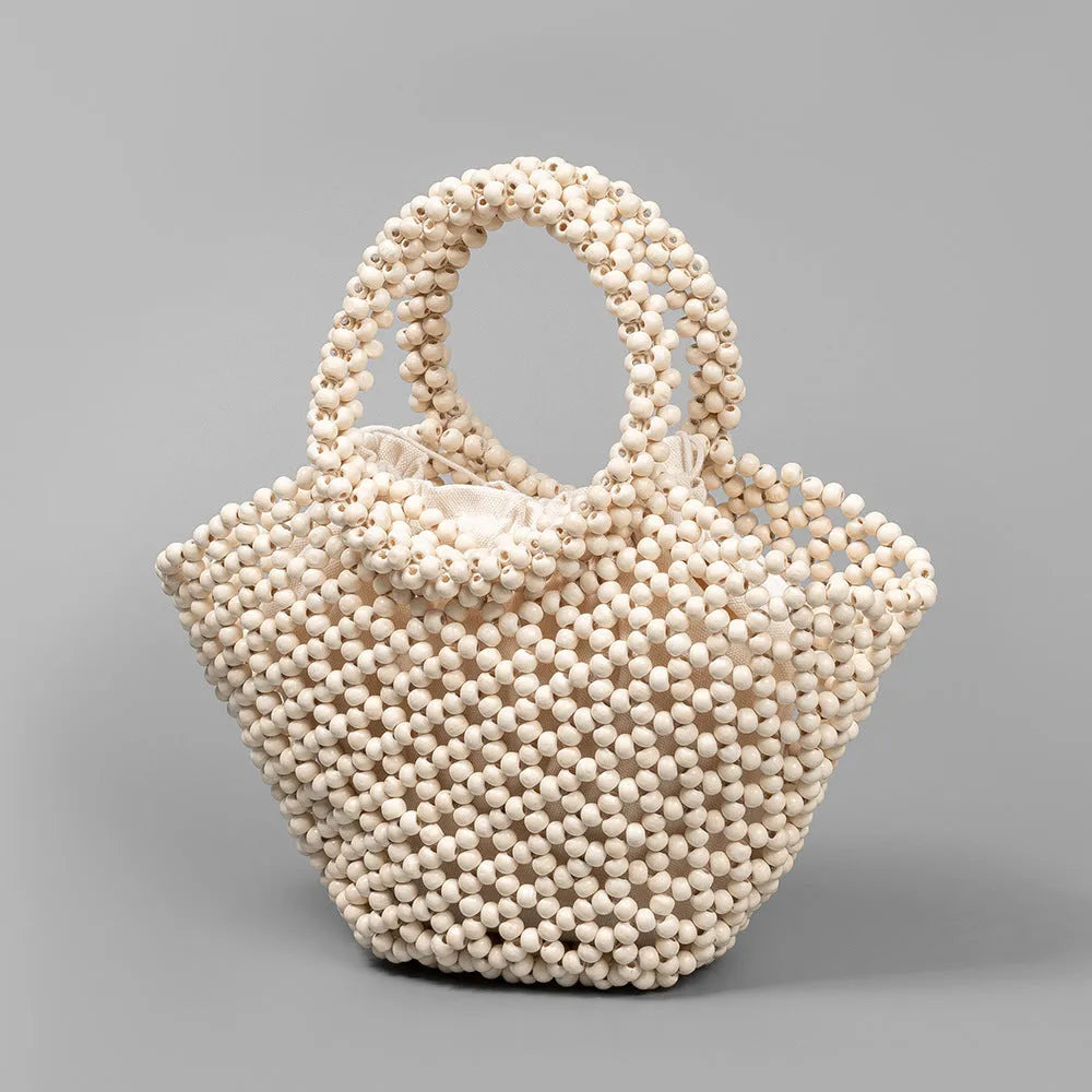 Hand-woven wooden bead beach bag in dumpling shape with strapless design.
