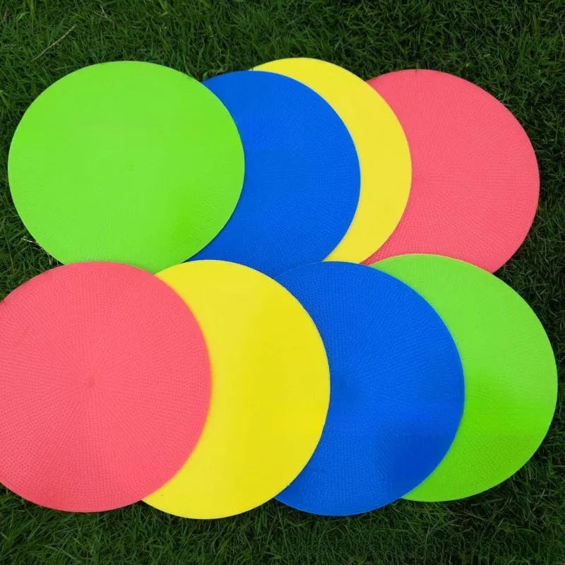 Soft yellow TPE football training target pad flat on grass, 23cm diameter.