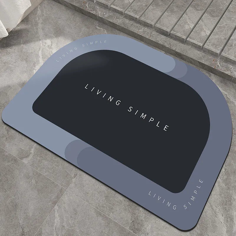 Oval grey polyester door mat with textured rubber non-slip backing on a wooden floor.