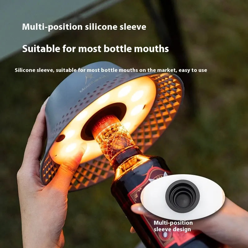 Beige wine bottle camping lantern with USB-C port and gear switch for light modes on wooden table.