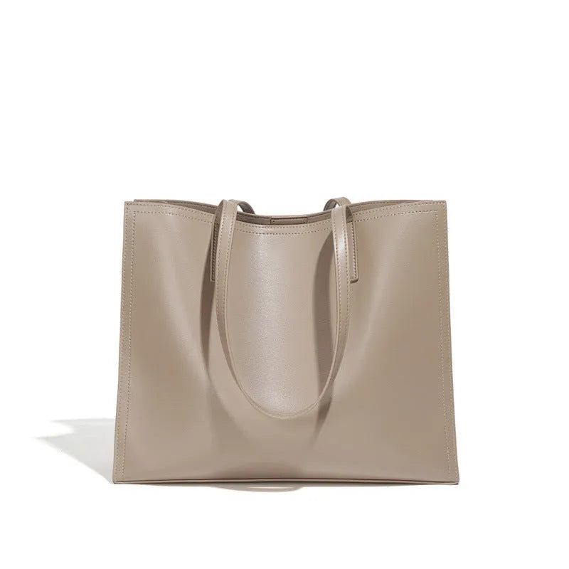 Women's brown genuine leather handbag with multiple internal pockets and single shoulder strap