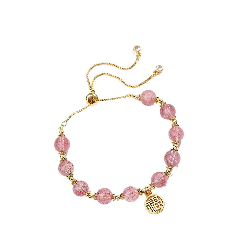 Women's Strawberry Quartz crystal bracelet with geometric design and fu character charm on wrist
