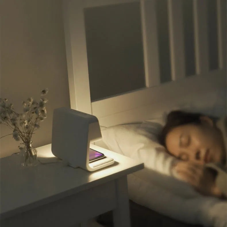 White bedside lamp with integrated wireless charging pad and LCD alarm clock display