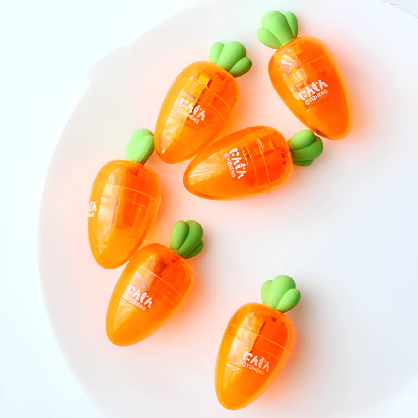 Orange carrot-shaped plastic pencil sharpener on a white background.