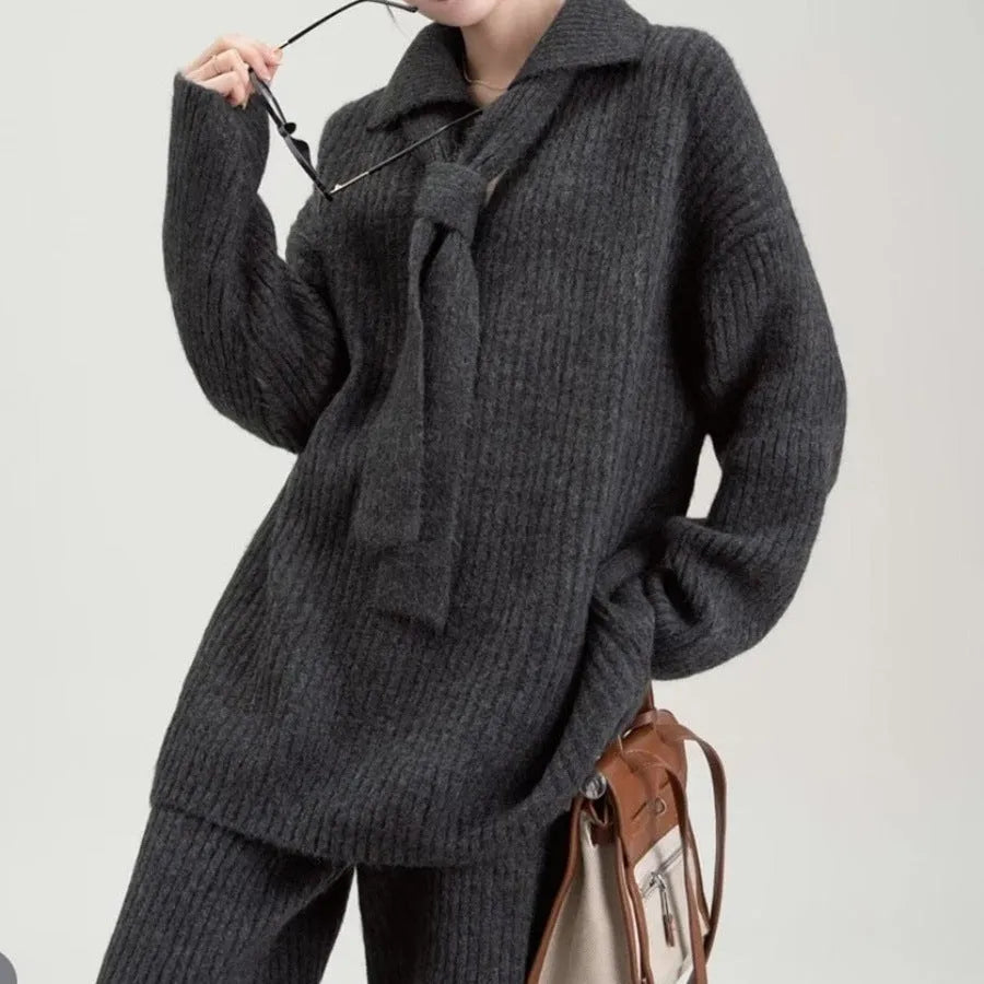 Women's beige knitted top and trousers two-piece set with long sleeves on a hanger.