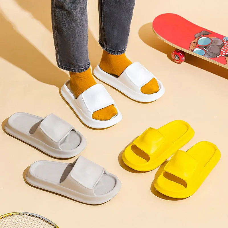 Pair of white EVA flip-flop slippers with a thick, textured sole on a tiled floor.