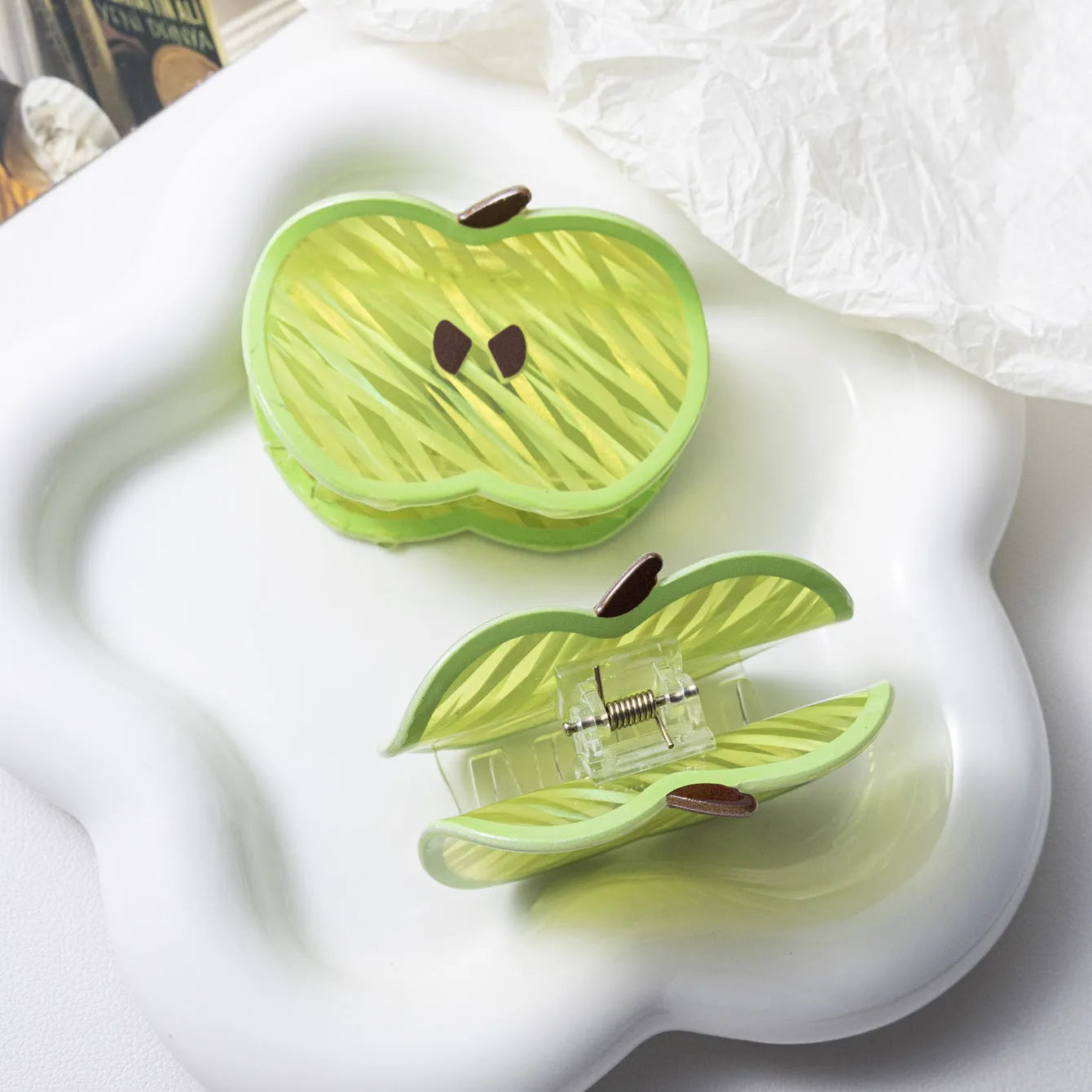 Green apple-shaped claw clip with polished PVC finish, 7.5cm long, on a plain background