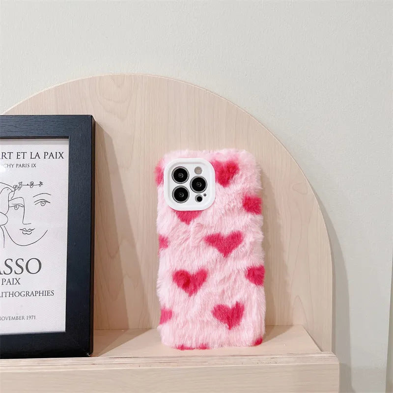 Pink silicone iPhone case with cartoon Love Plush design, shown fitted on a mobile phone.