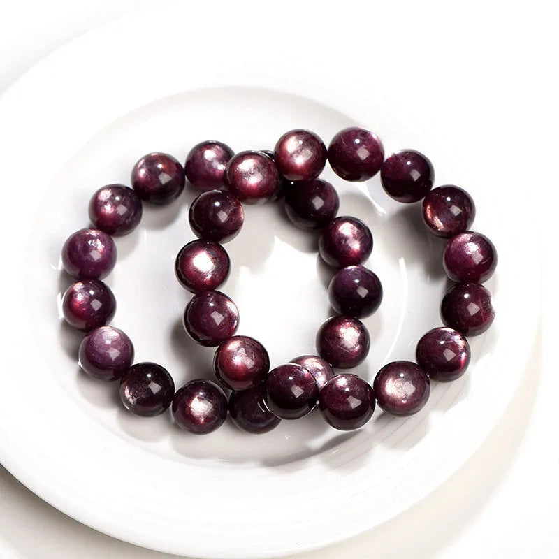 Purple lepidolite crystal round beads bracelet on a wrist, showing polished gemstone beads.