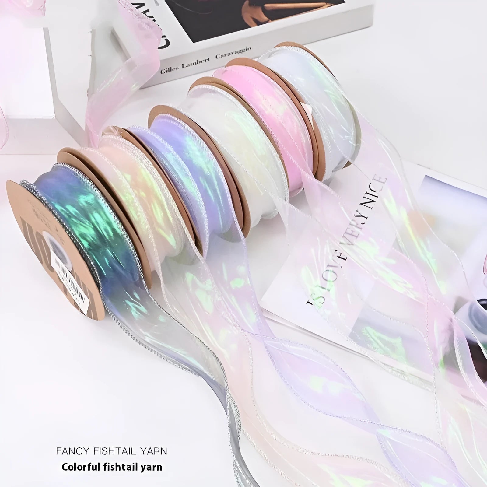 Roll of colourful fishtail yarn mesh ribbon showing its textured, wavy edge, with a colour selection including pink, yellow, and blue.