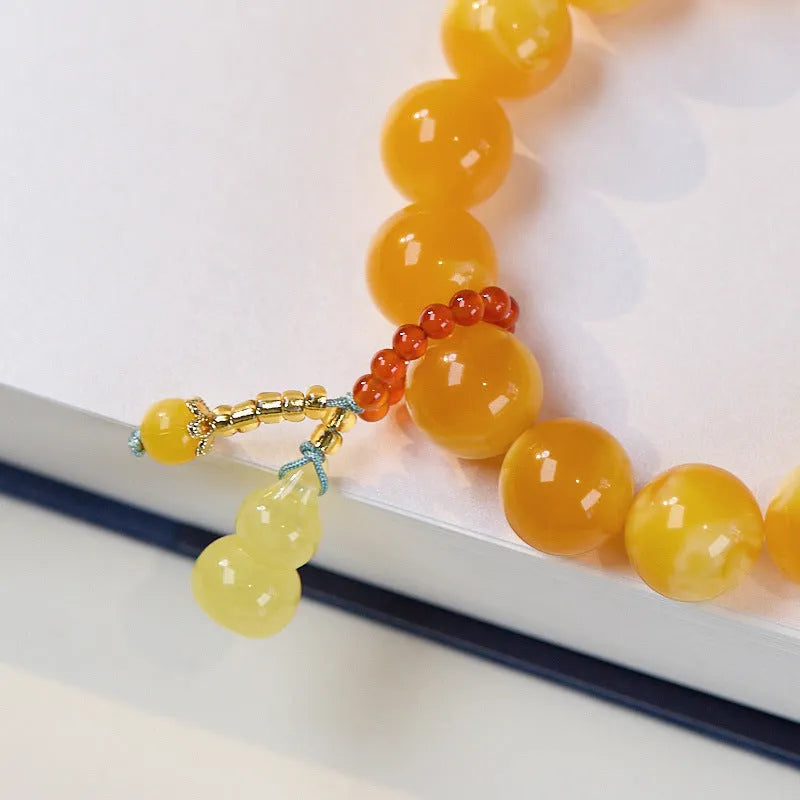 Natural beeswax Gourd Fu Lu bracelet in two sizes 12mm and 6mm on plain background